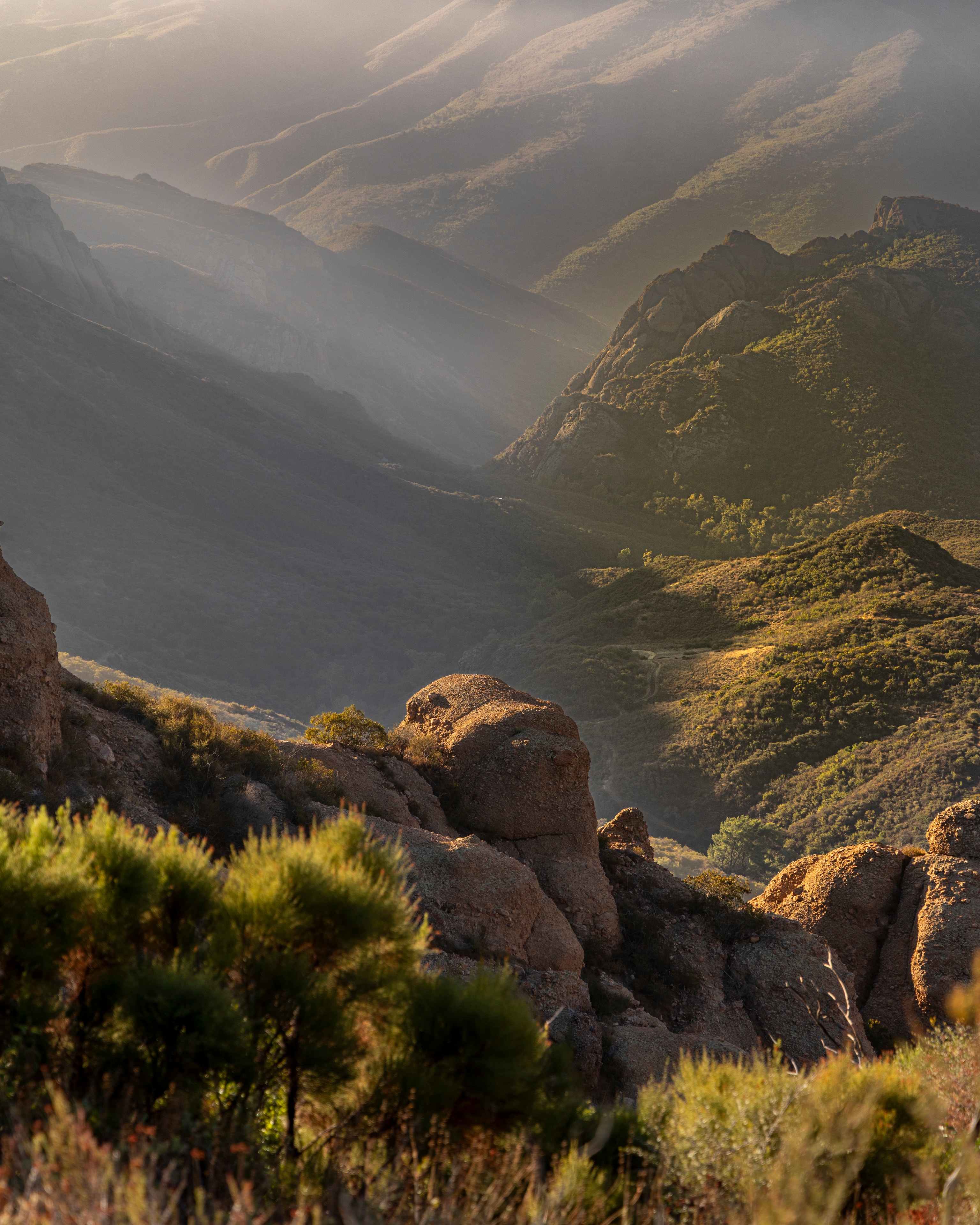 Misty valley with boulders and light rays, Mishe Mokwa Trail