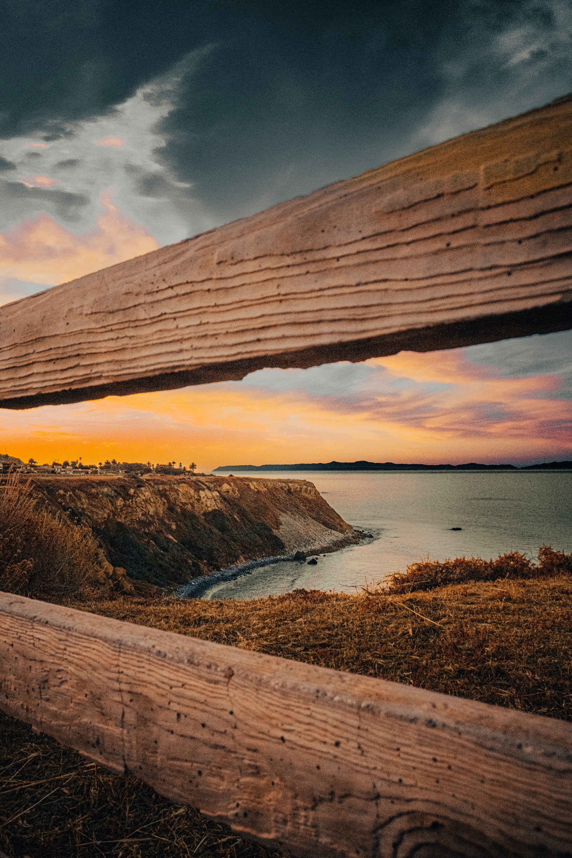 Coastal sunset framed through driftwood