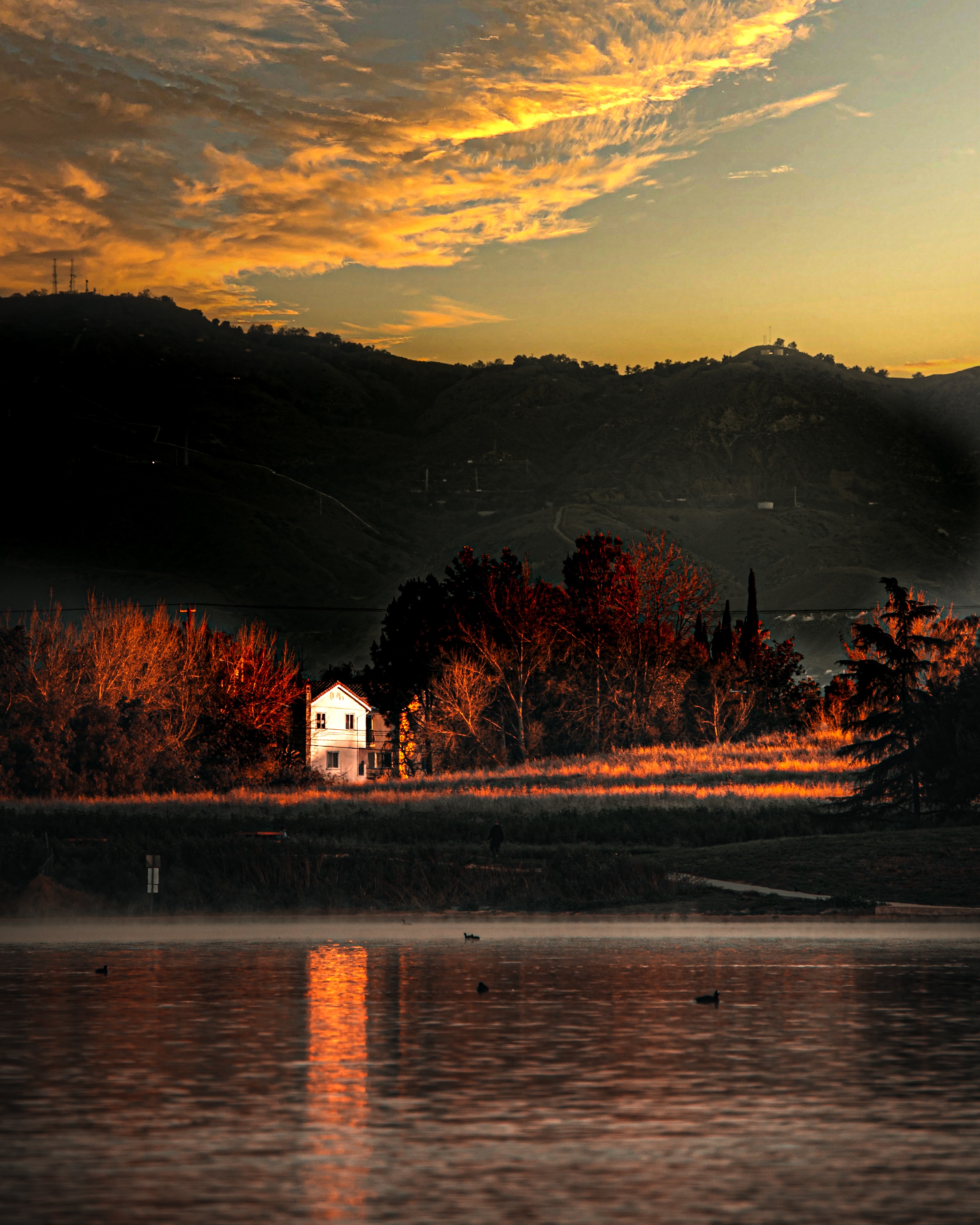 House by lake at golden hour sunset