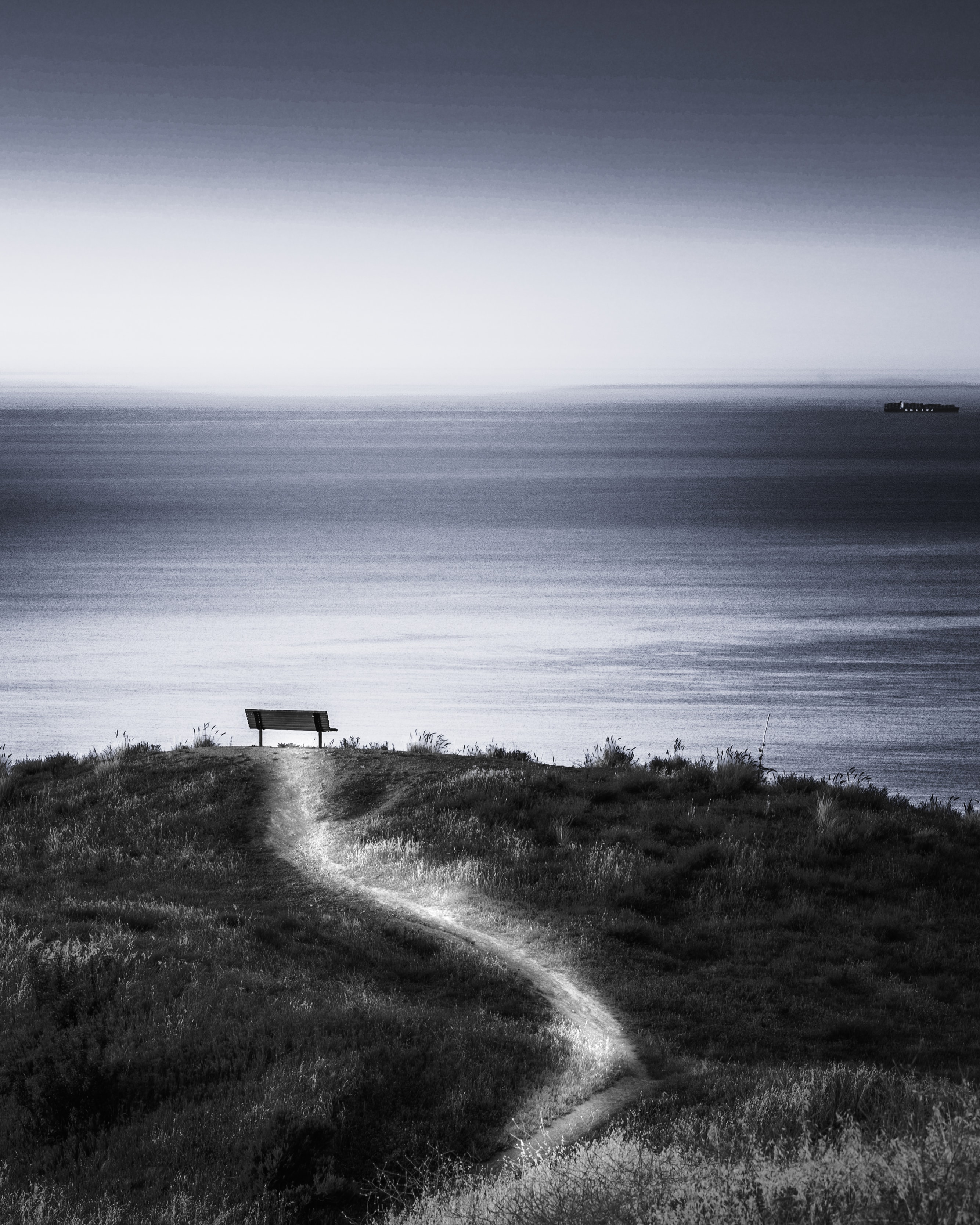 Bench on coastal cliff path overlooking sea