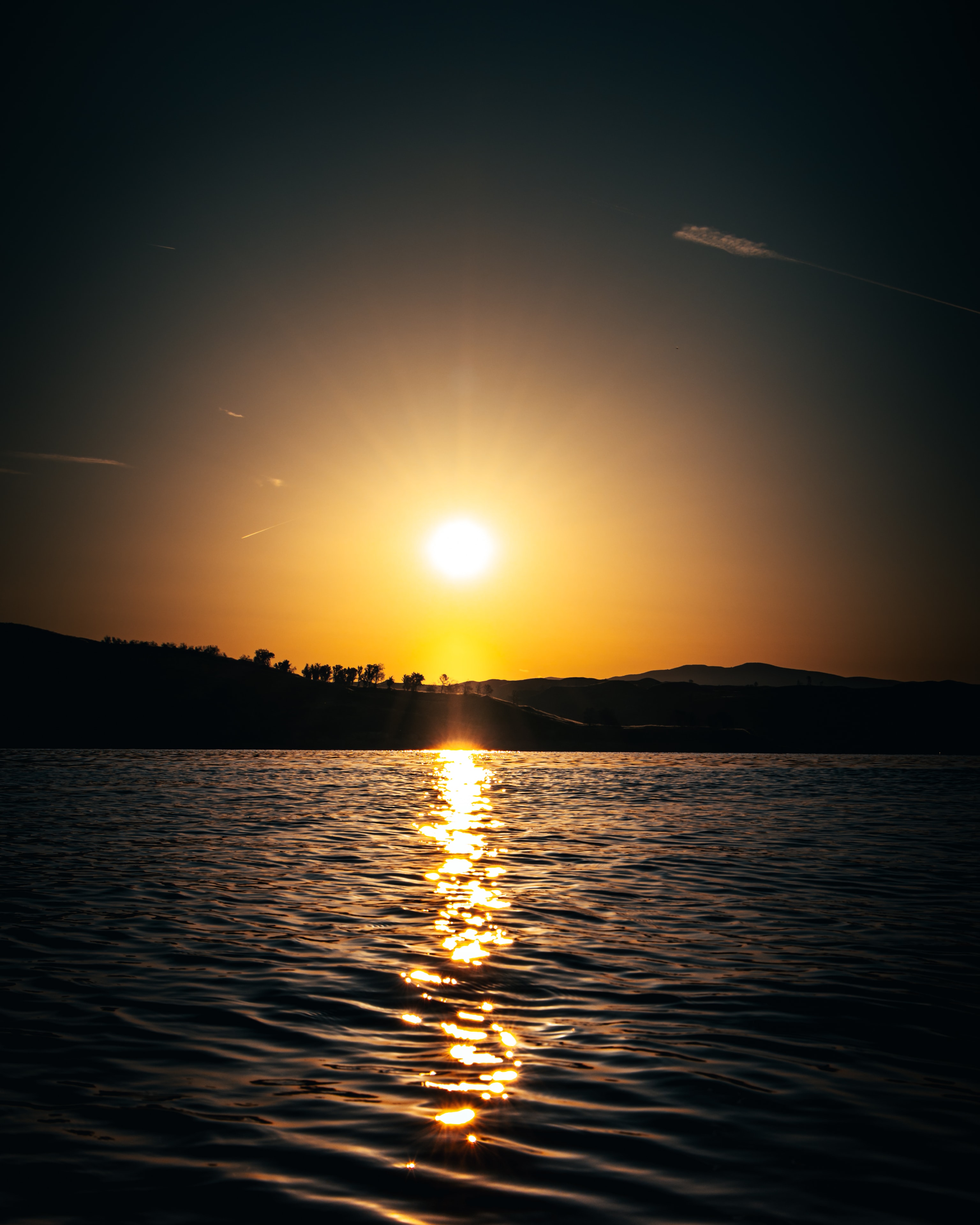 Golden sunset reflected across calm lake water