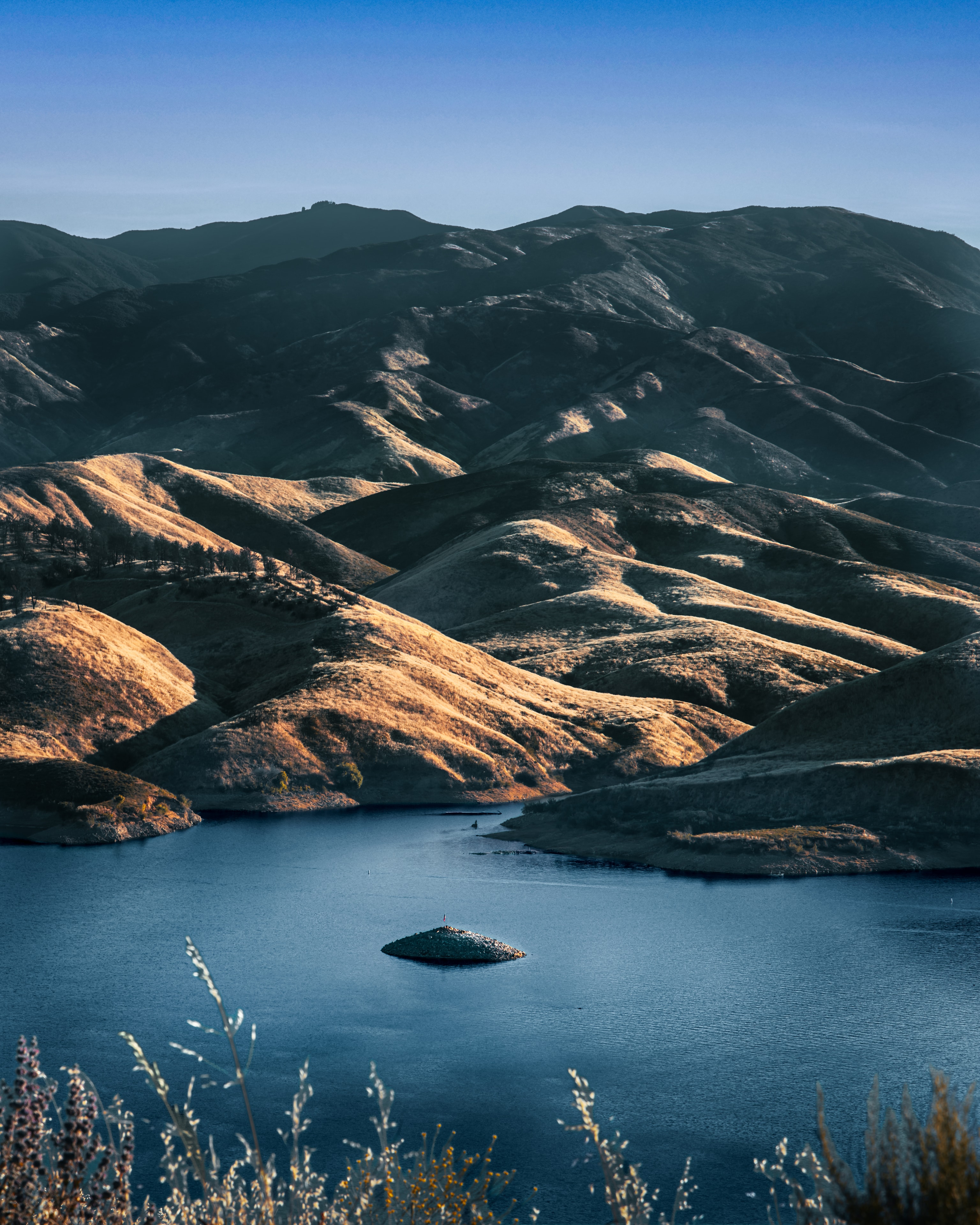 Mountain lake with small island and rolling hills