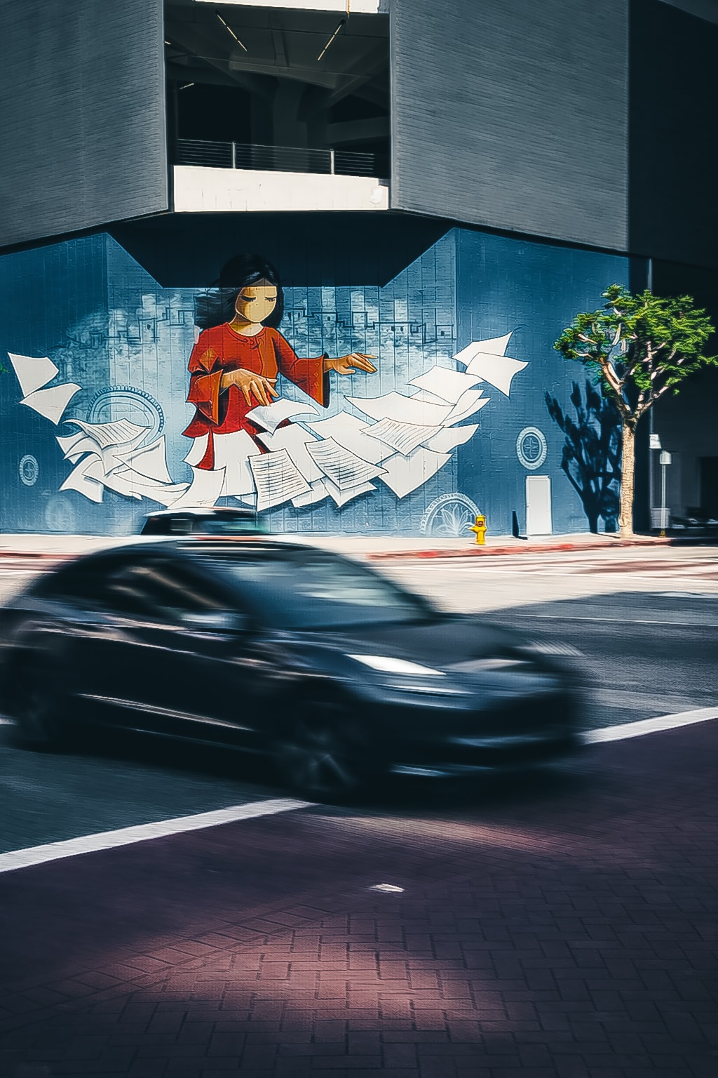 Urban mural with motion-blurred car passing