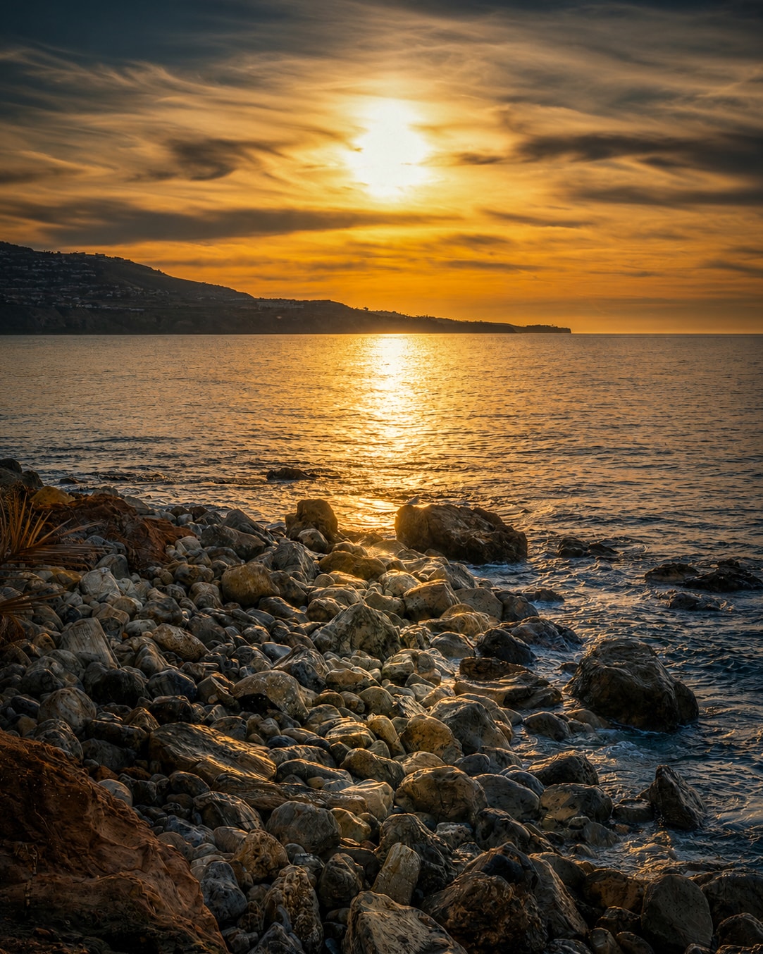 Rocky coastline with blazing sunset over the ocean