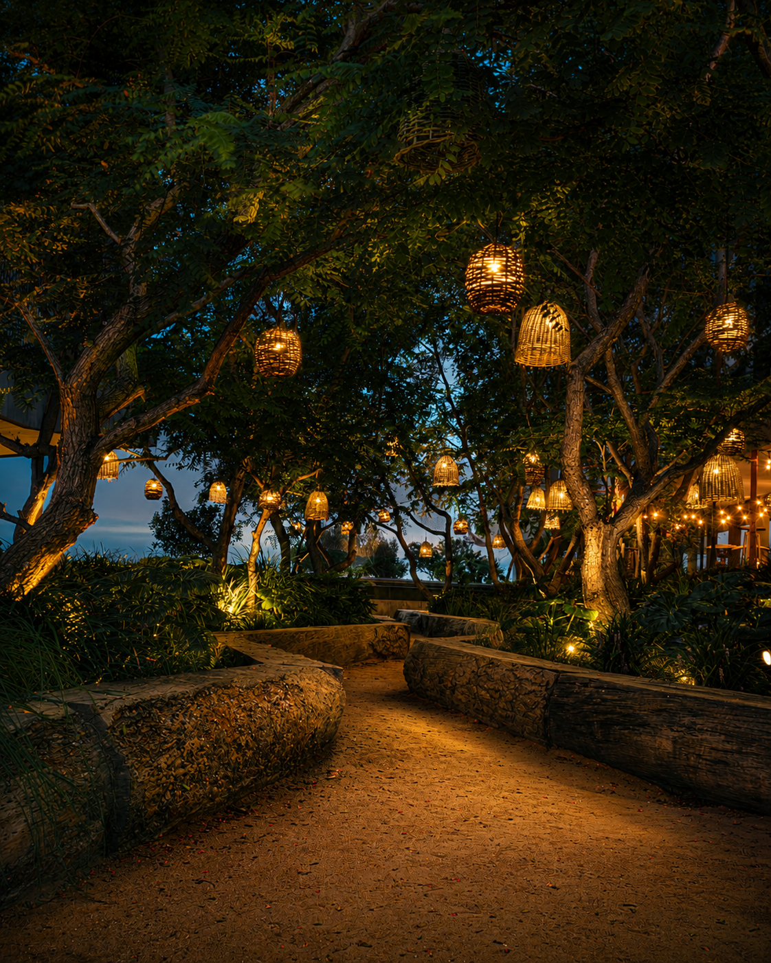 Illuminated garden path with wicker lanterns at night