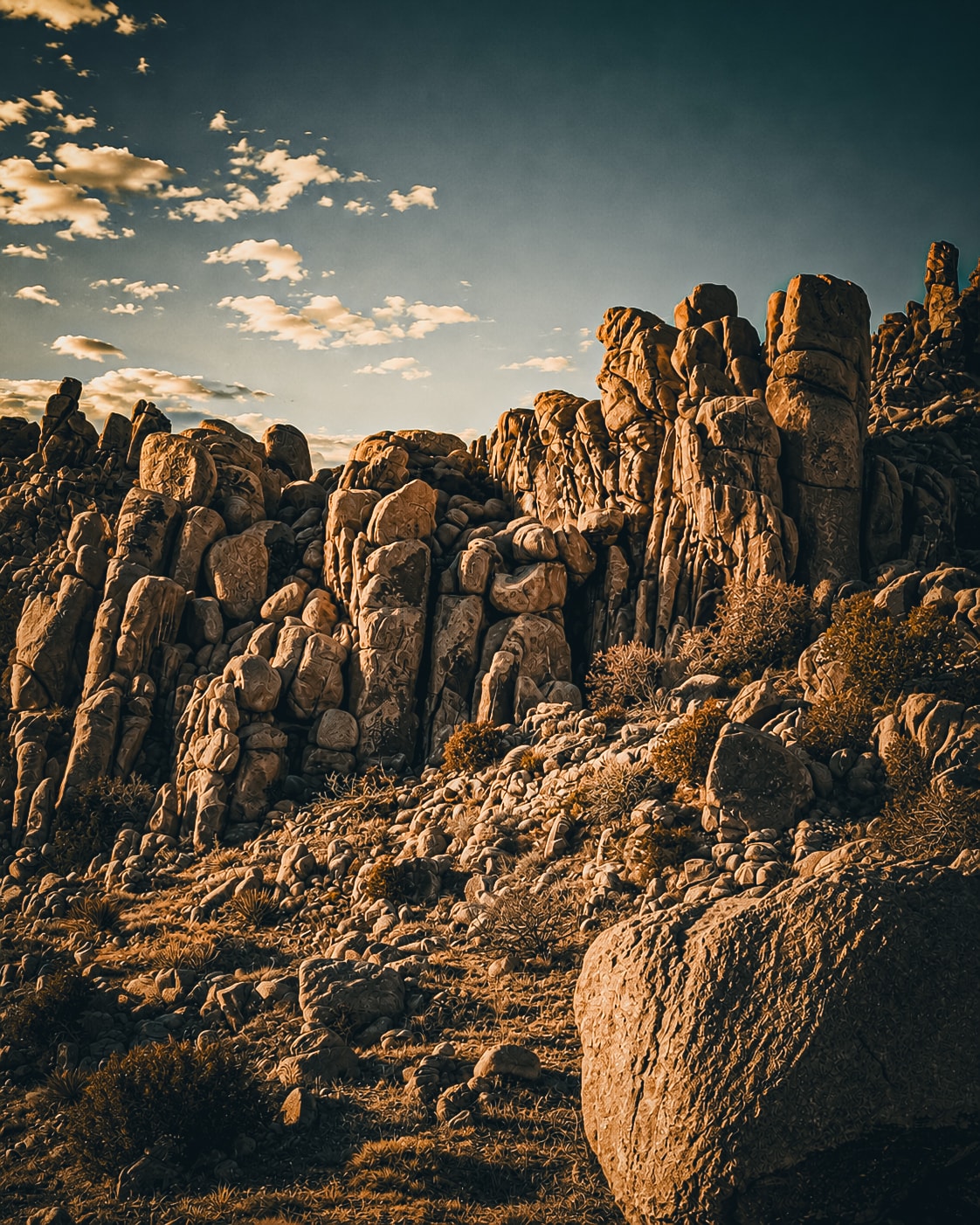 Rugged desert boulders under dramatic cloudy sky