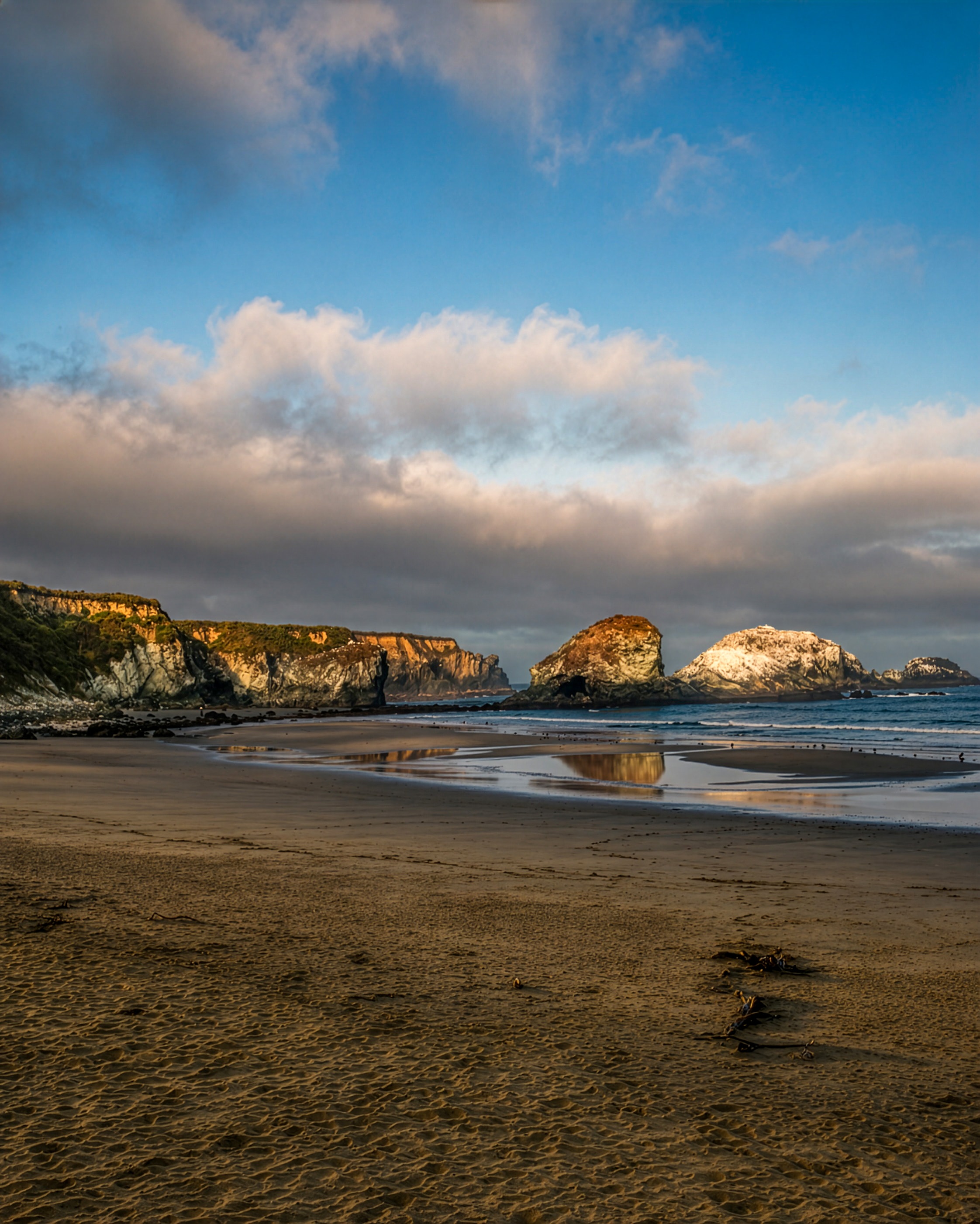 Wide sandy beach with sea stacks at golden hour
