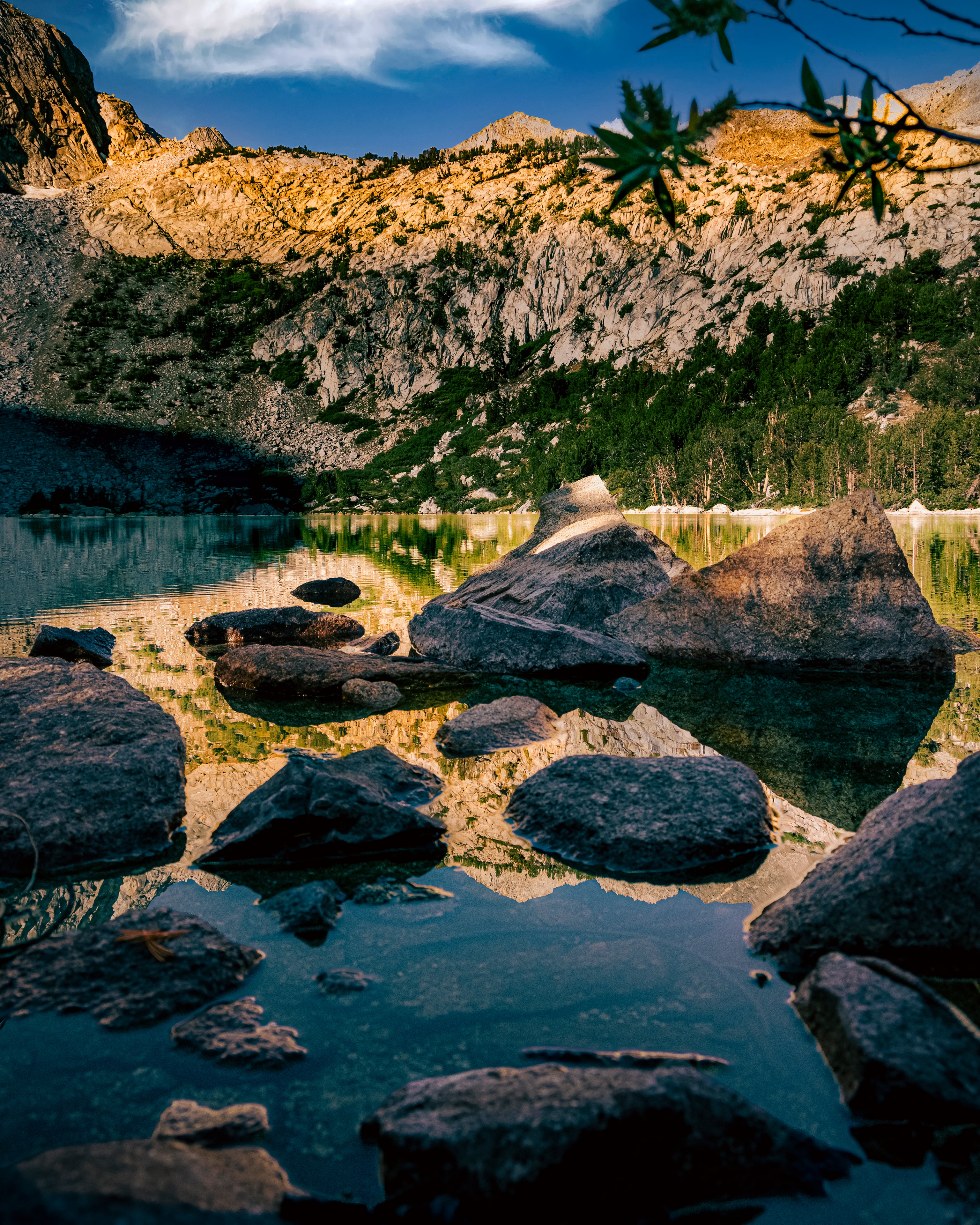 Alpine lake with granite boulders and mountain reflections, Eastern Sierra